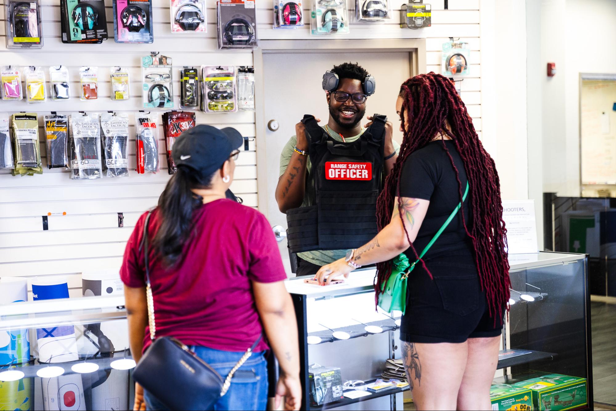 Man and Two Women standing at checkout counter in Shop