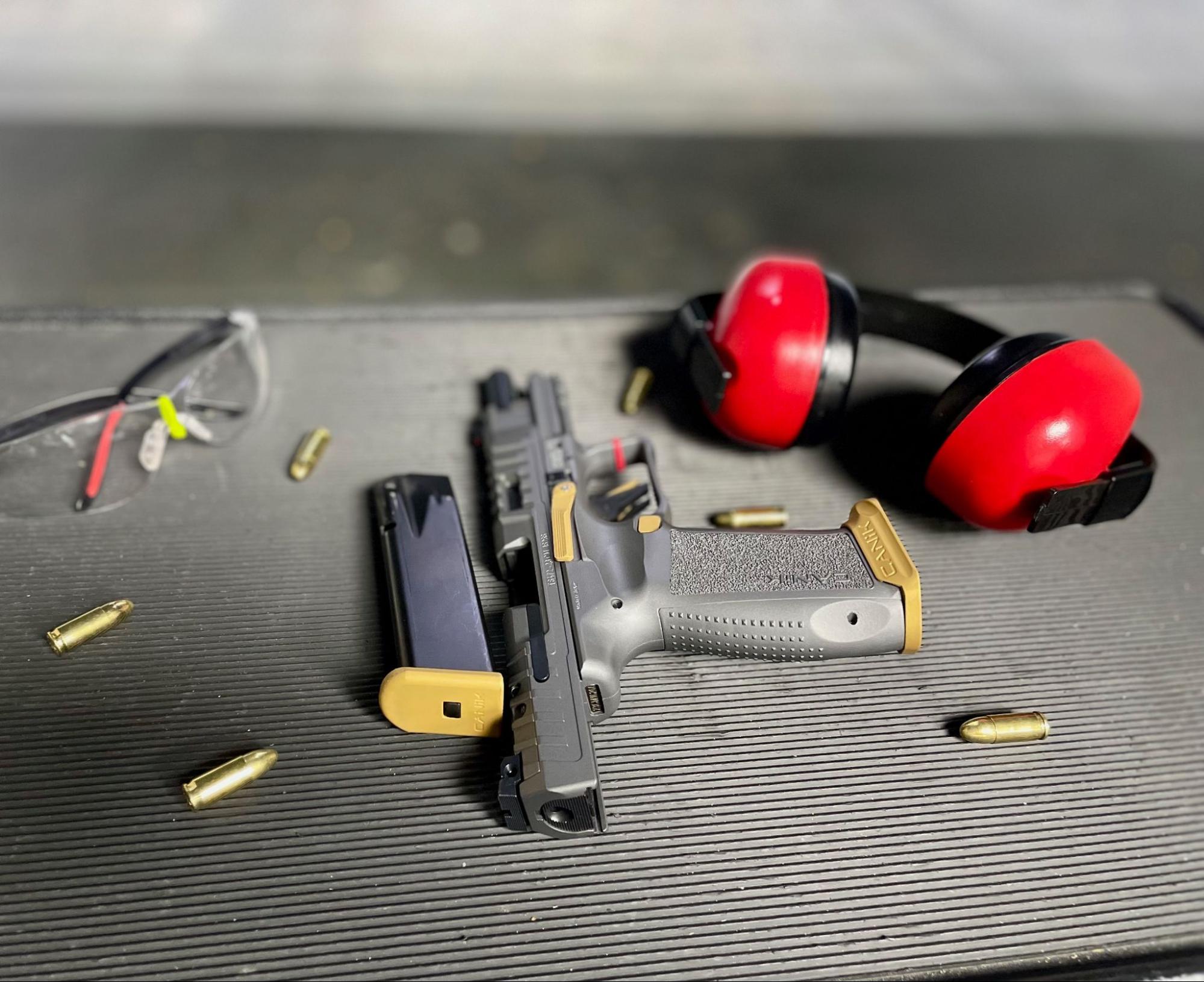 Gun, bullets, eye wear, ear cover sitting on a tray in Shop